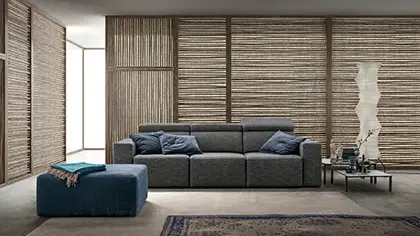 divano elegante di colore grigio con sedute estraibili e poggiatesta reclinabili.