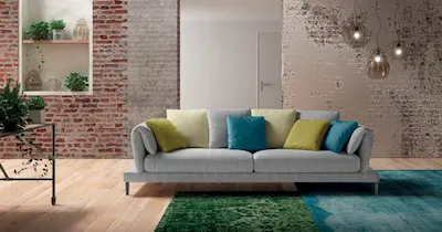 immagine di un divano elegante inserito in un living con una parete di mattoni.