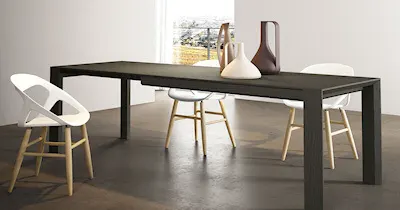 immagine di un tavolo con sedie disposte attorno, in un ambiente semplice e accogliente.